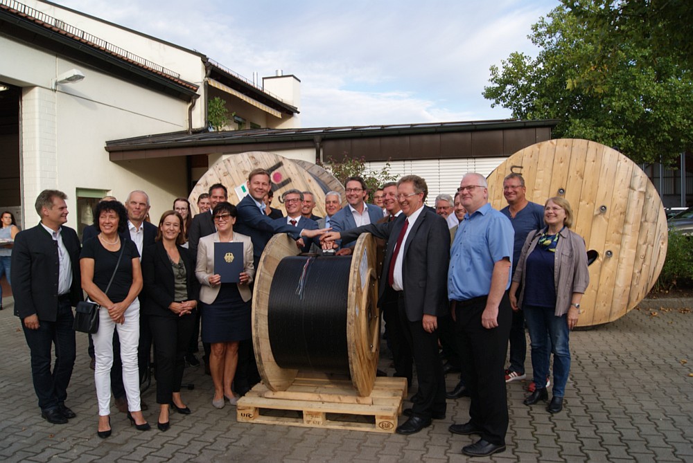 Andreas Scheuer (Bundesminister für Verkehr und digitale Infrastruktur, Mitte, hinter der Kabeltrommel), Bürgermeister Christian Meyer (Markt Hengersberg, Vordergrund, 2. v. r.,) Dr. Annette Schumacher (Mitglied der Geschäftsführung aconium, 4. v. l.) mit weiteren Teilnehmern bei der Übergabe des Förderbescheides in endgültiger Höhe. Markt Hengersberg, 9. September 2018.